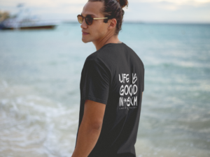 t-shirt-mockup-of-a-hipster-guy-wearing-sunglasses-at-the-beach-shore-a12726